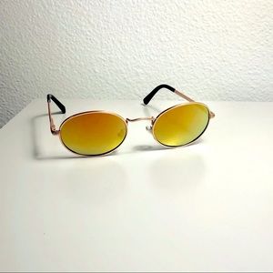 Unisex oval Polaroid sunglasses with orange and green hues and metal frame.